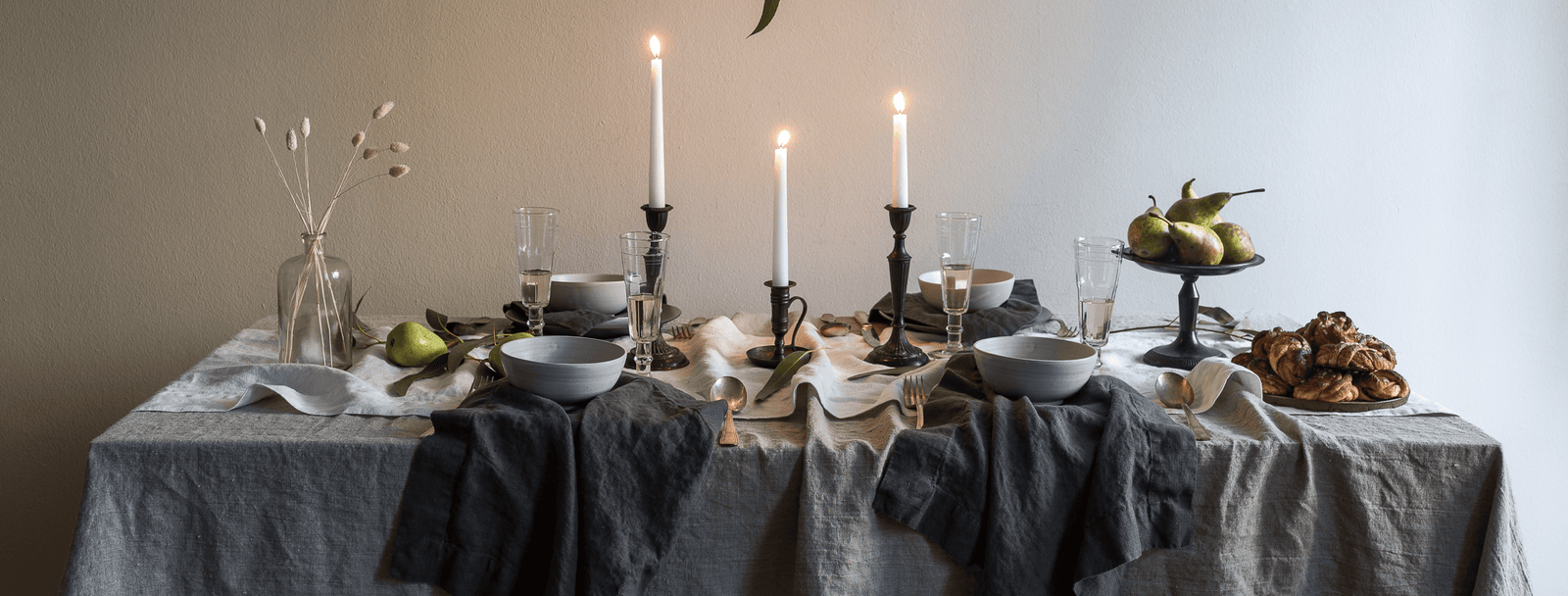 Tableware and candle on linen tablecloth