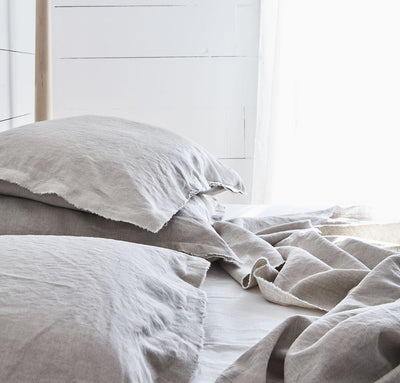 bedroom scene with 100% linen summer cover blanket with frayed raw edge detail natural beige tan color